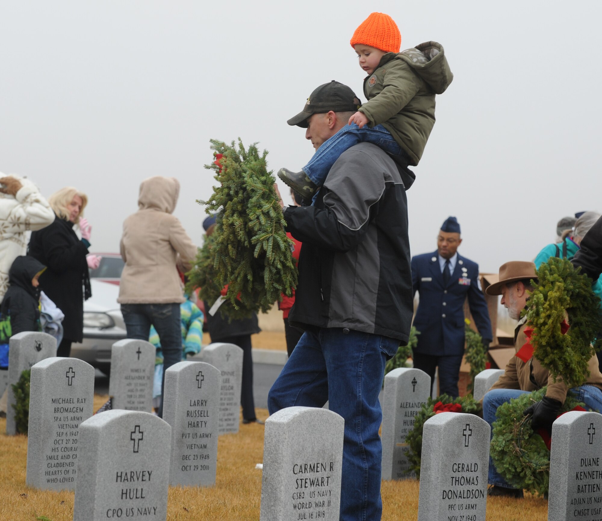 Families and friends of fallen veterans gather to place wreaths upon the burial stone of their loved ones during Wreaths Across America Dec.13. 2014, at the Washington State Veterans Cemetery in Medical Lake, Wash. The event is held annually to honor fallen heroes. (U.S. Air Force photo/Staff Sgt. Samantha Krolikowski)