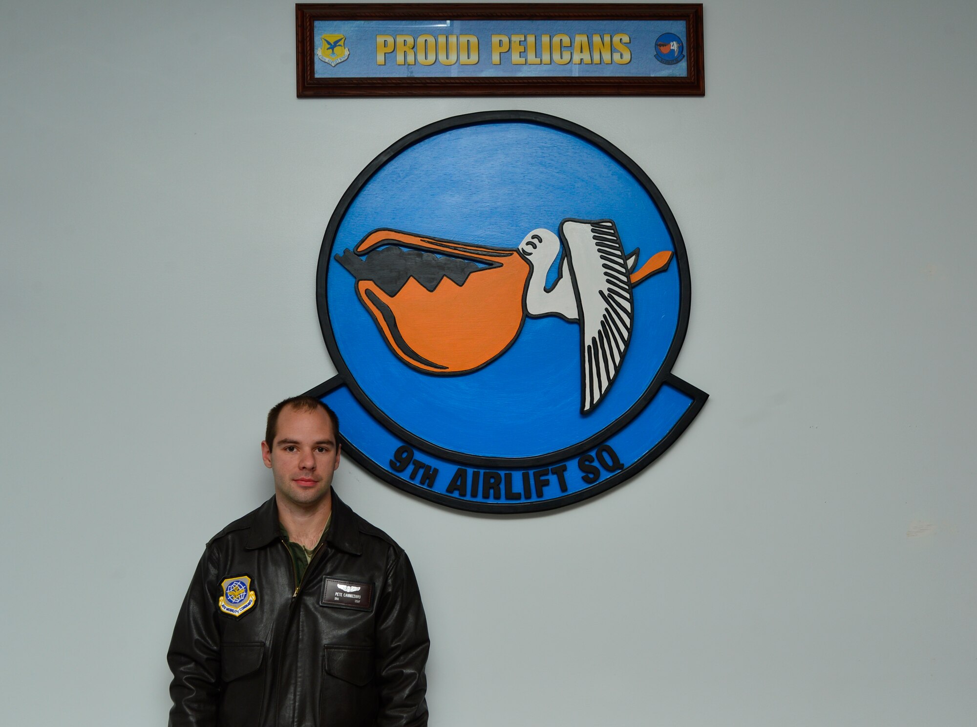 Senior Airman Peter Cannizzaro, 9th Airlift Squadron loadmaster, poses for a photograph Dec. 15, 2014, in front of his squadron emblem at Dover Air Force Base, Del. Cannizzaro provided first aid care during a rollover car accident that ejected the driver and trapped another passenger inside the vehicle on Dec. 8, 2014, on Delaware Route 9 in Dover, Del. (U.S. Air Force photo/Airman 1st Class William Johnson)