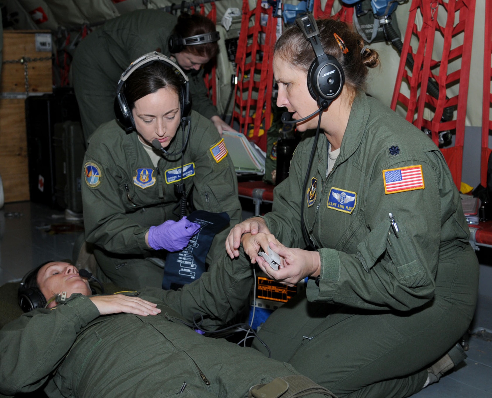 Flight nurse Lt. Col. Mary Ann Hayes and aeromedical technician Staff Sgt. Robin Messer both from the 45th AES, MacDill AFB, Florida, track the vitals of a simulated patient played by Master Sgt. Mary Beth Young, aeromedical technician, 45th AES  during a three-day training mission held Dec. 12, 2014. To stay proficient at their lifesaving skills, the technicians routinely climb aboard a MacDill based KC-135 to fine tune their caregiving skills. (U.S. Air force photo/Tech. Sgt. Peter Dean/released)