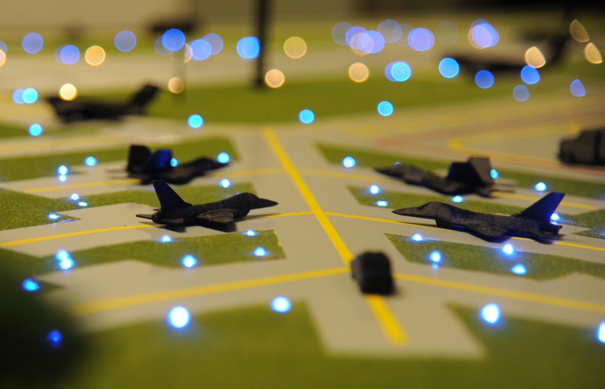3-D printed aircraft models sit on top of an illuminated airfield training aid table used in the 334th Training Squadron airfield management course Dec. 12, 2014, at Cody Hall, Keesler Air Force Base, Miss.  Utilizing the model, which is a scaled representation of an airfield, will increases understanding, productivity and efficiency in the classroom. (U.S. Air Force photo by Kemberly Groue)