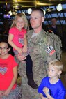 Master Sgt. Grant Lonski is greeted by family Oct. 17, 2013, upon returning to Hector International Airport, Fargo, after a seven-month deployment to Afghanistan. Lonski serves with the North Dakota Air National Guard’s 119th Security Forces Squadron, which provided security support at Bagram Airfield from March to October 2013. (U.S. Air Force photo/Staff Sgt. Natahanael Baardson)