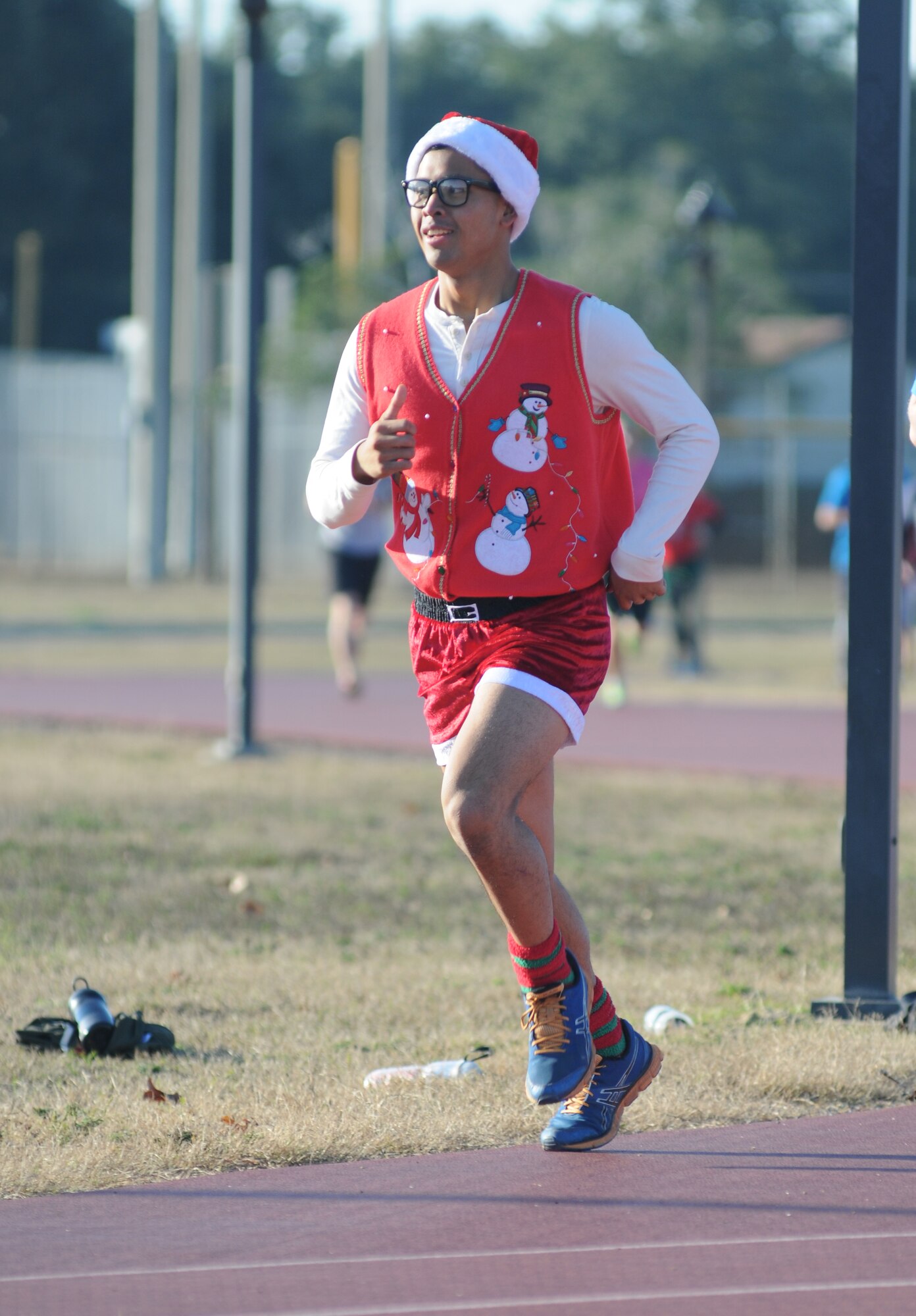 Lance Cpl. Jason Pil, Keesler Marine Detachment weather student, makes a lap around the Triangle Track during a U.S. Marine Corps "Toys for Tots" Foundation fundraising event Dec. 13, 2014, at Keesler Air Force Base, Miss.  Approximately 160 Marines participated in the event, and more than 180 toys were collected for the community outreach event benefiting the Marine Corps "Toys for Tots" campaign. (U.S. Air Force photo by Kemberly Groue)