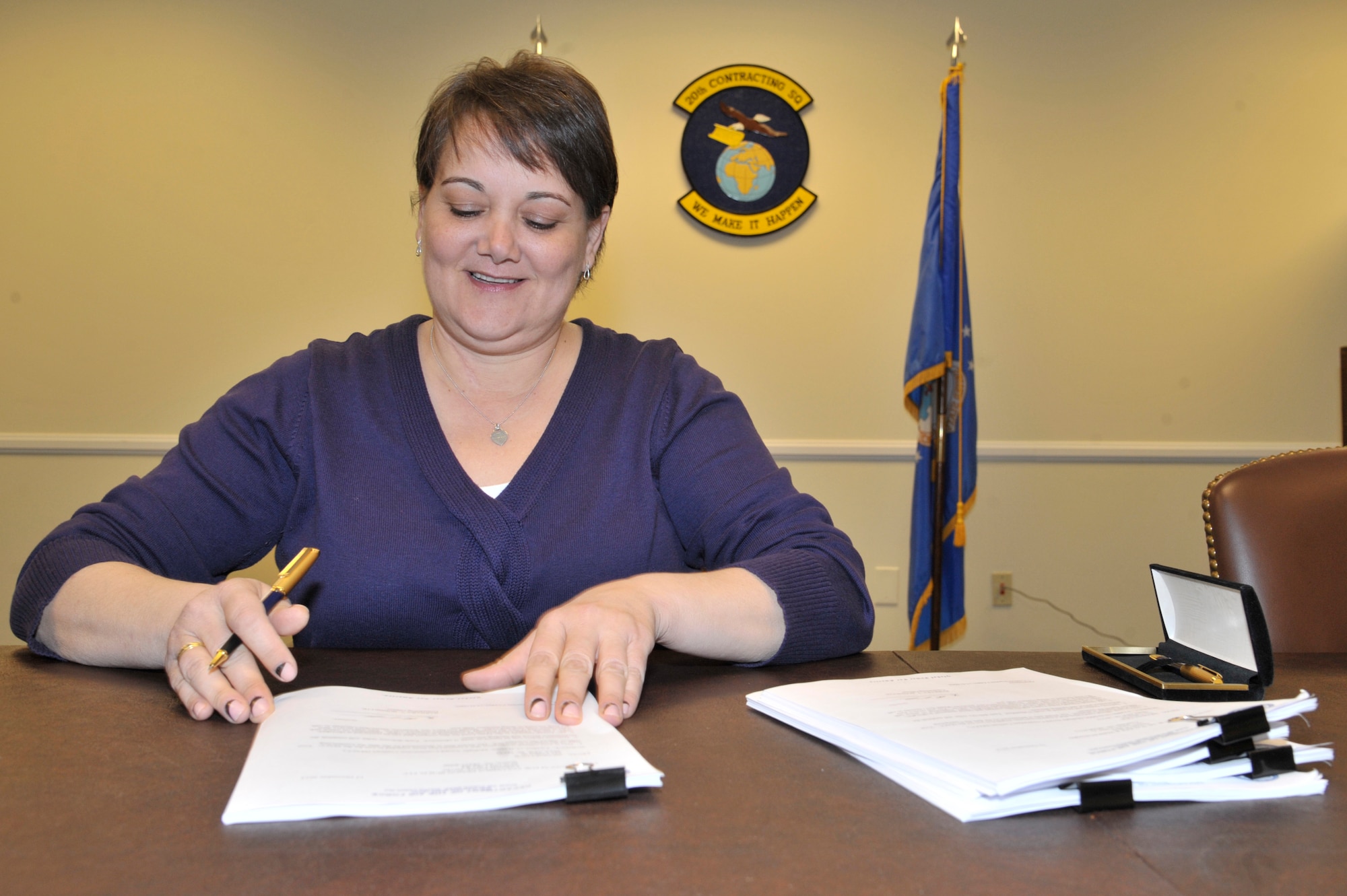 Barbara Bonnette, 20th Contracting Squadron infrastructure flight chief, signs one of six multiple award construction contracts at Shaw Air Force Base, S.C., Dec. 12, 2014. The MACC is a contract vehicle that includes six qualified construction contractors, which will be used to award future Shaw construction projects and reduce acquisition time by 50 percent. The contracts are worth $150 million over five years and are the largest contracts awarded in 20th CONS history. (U.S. Air Force photo by Airman 1st Class Jonathan Bass/Released)