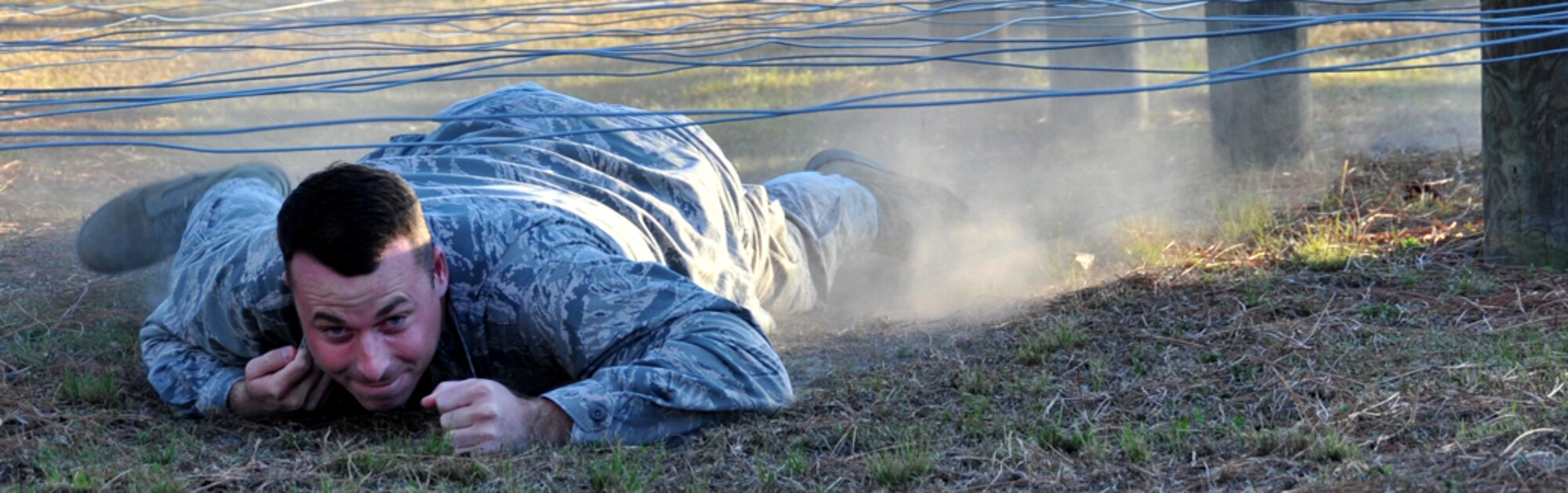 1st Lt. Brandon Dutton, a maintenance officer with the 403rd Wing at Keesler Air Force Base, negotiates a low-crawl wire obstacle in a field exercise during the Junior Officer Leadership Development Course here. (U.S. Air Force Photo/Maj. Marnee Losurdo)