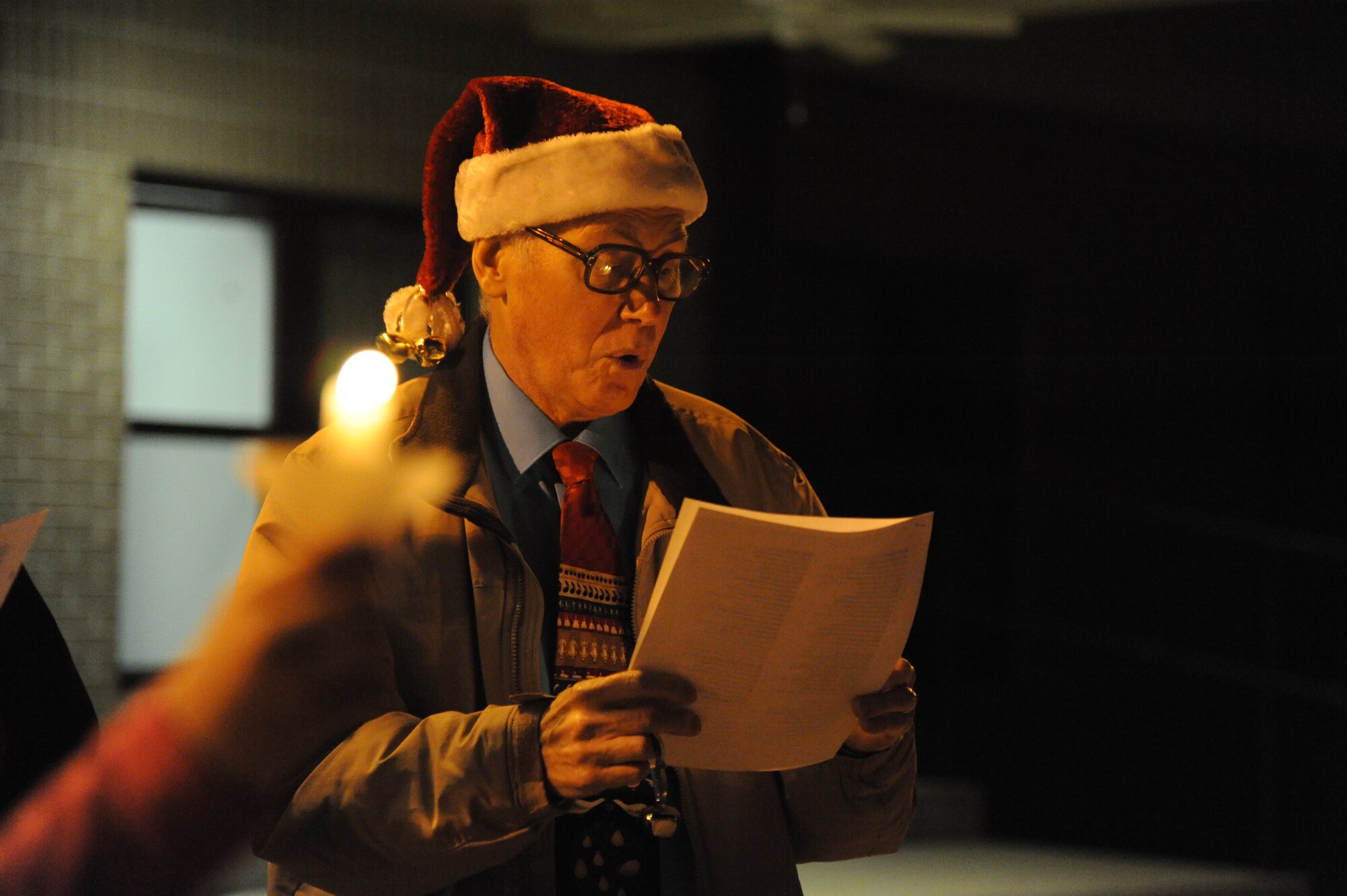 Retired Capt. Allan Micksch, Keesler community services choir director, sings a Christmas song while caroling around the Triangle Courtyard Dec. 12, 2014, at Keesler Air Force Base, Miss.  Following the Christmas caroling, hot chocolate and cookies were available to everyone in attendance.  (U.S. Air Force photo by Kemberly Groue)