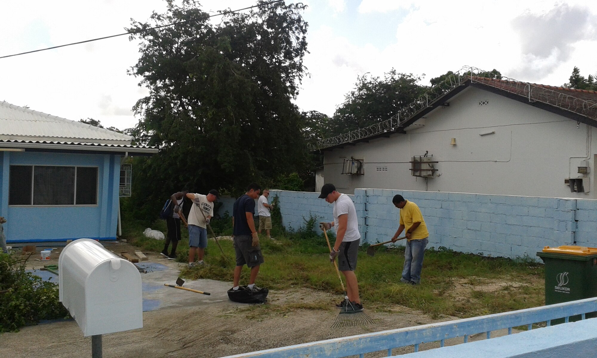 U.S. Forward Operating Location and Fundashon Sentro di Dama or SEDA volunteers clean the yard of a community center Dec. 9, 2014. SEDA, a non-profit organization, supports women, children and teens in crisis through a variety of outreach projects. The USFOL volunteers partnered with SEDA to refurbish the community center and revive the landscape. Engagements such as these demonstrate the USFOL team’s eagerness for community involvement and their appreciation for the hospitality they receive from the citizens of Curacao. (Courtesy Photo)
