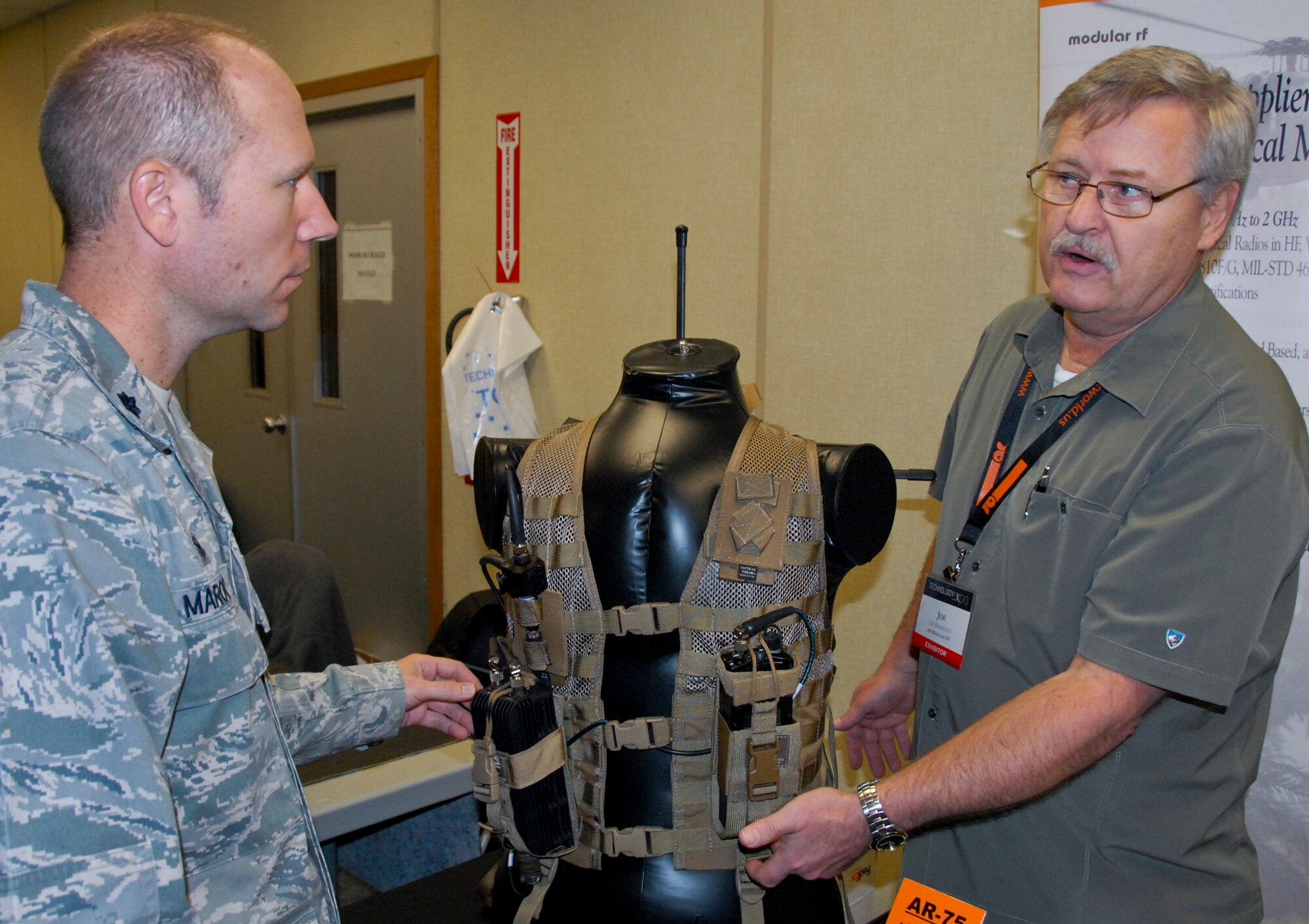 Lt. Col. Brandon Maroon, 96th Logistics Readiness Squadron commander, is briefed on a man pack radio system, used for patrol or reconnaissance, by Joe Reminder, regional sales manager with AR Modular RF, a tactical booster amplifiers manufacturing company, at the Technology Expo, at Eglin Air Force Base, Fla. Dec. 11. Exhibitors from across the United States offered information and displays about the latest defense technologies; logistical and engineering services and storage solutions; among other technologies. (U.S. Air Force photo/Kevin Gaddie) 