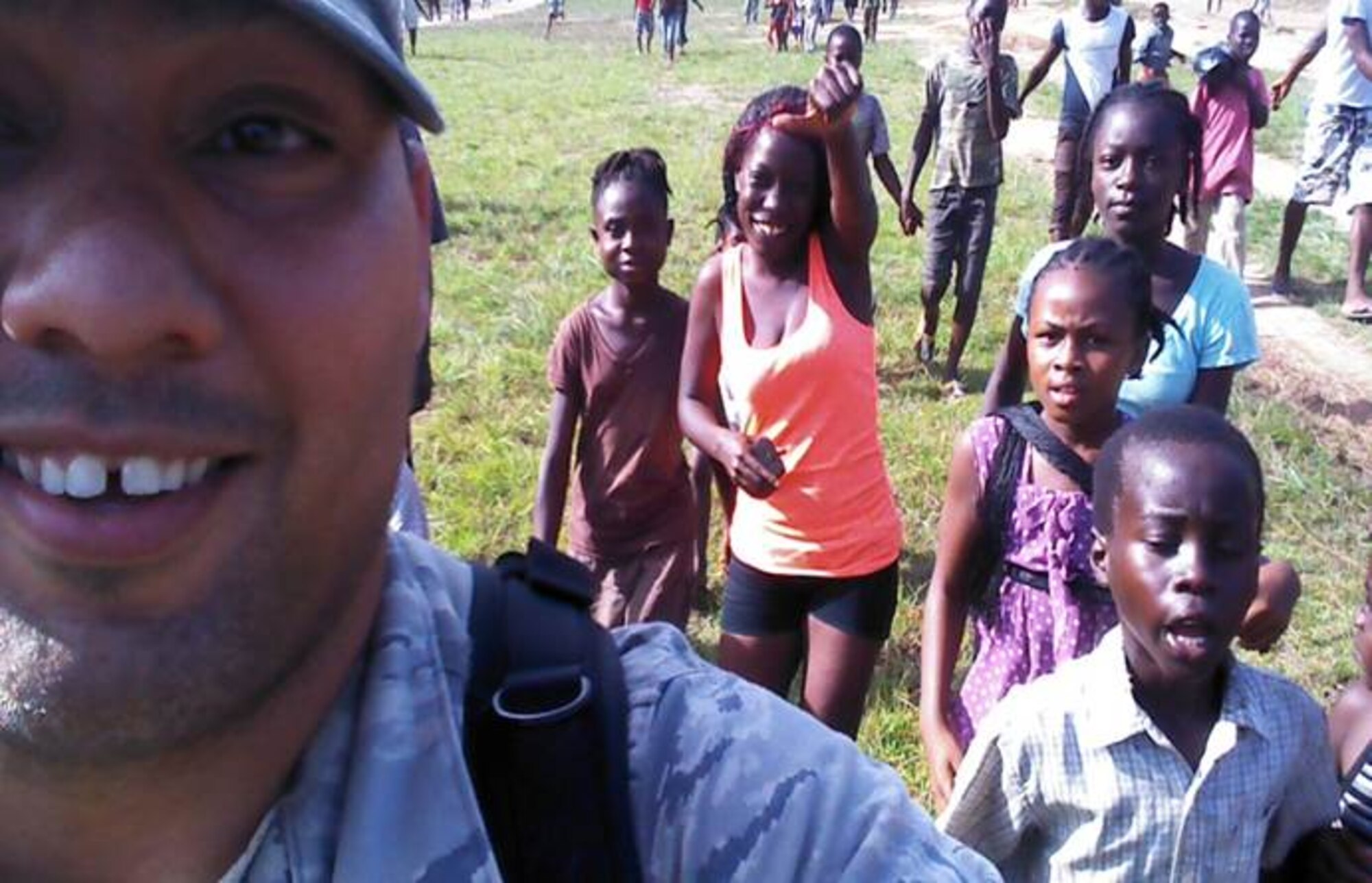 Tech. Sgt. Robert Lloyd, 786th Civil Engineer Squadron pavements and equipment operator, takes a picture with children during a 60-day deployment to Liberia, Africa. Eleven U.S. Air Forces in Europe and Air Forces Africa engineers, started the first operations to build Ebola treatment facilities in support of Operation United Assistance. (Courtesy photo)