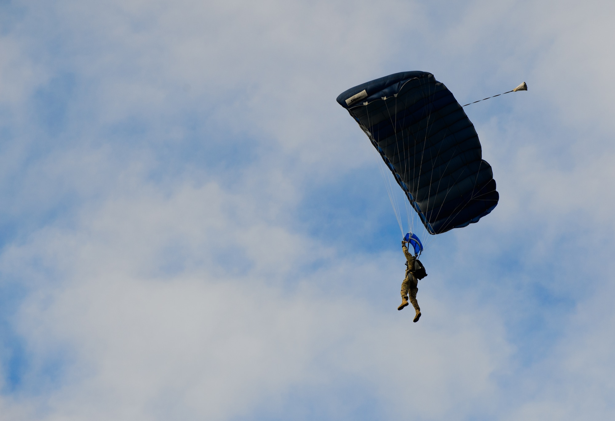 A NATO partner paratrooper guides his parachute during training Dec. 15, 2014 at Alzey Drop Zone, Germany. Airmen, Soldiers and NATO partners participated in a toy drop operation, which was used to train and deliver toys to less fortunate children. (U.S. Air Force photo/Senior Airman Armando A. Schwier-Morales)