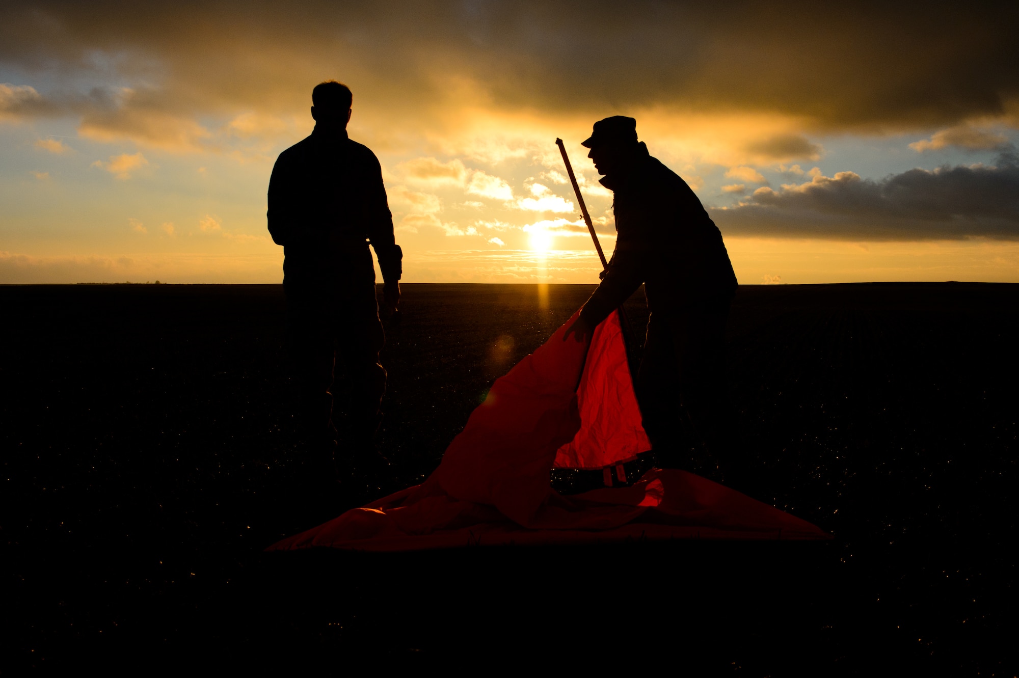 Two drop zone officers set up the landing beacon for paratroopers and Santa during a toy drop operation Dec. 15, 2014 at Alzey Drop Zone, Germany. The officers were part of a toy drop operation designed to donate toys to less-than-fortunate children collected by the Kaiserslautern Military Community. (U.S. Air Force photo/Senior Airman Armando A. Schwier-Morales)