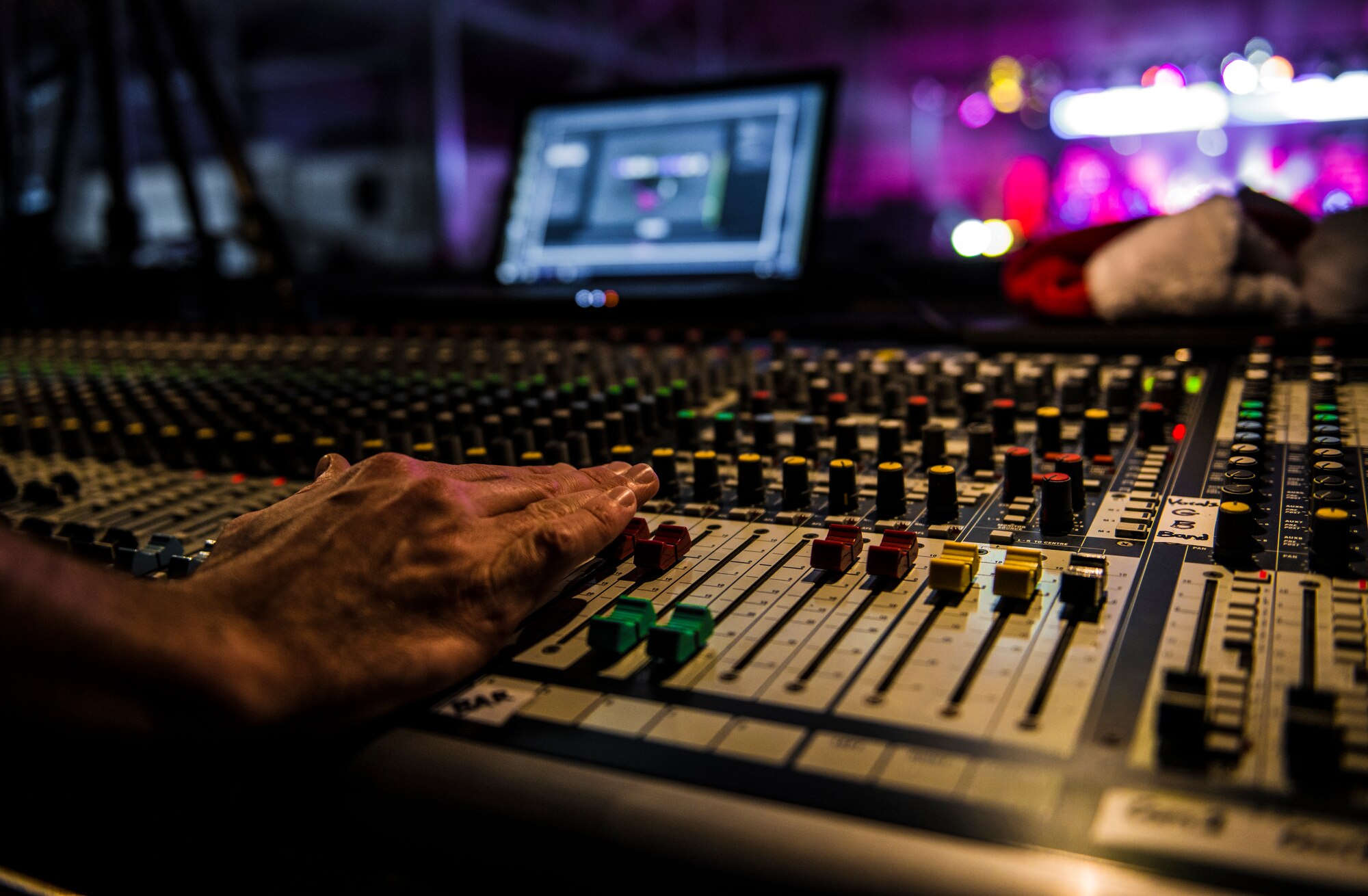 A lighting technician adjusts the lights during a Tops In Blues show Dec. 13, 2014, at Incirlik Air Base, Turkey. Tops In Blue uses top of the line equipment with 556 lights in 50 fixtures using over two miles of cable for each show. (U.S. Air Force photo by Airman Cory W. Bush/Released)