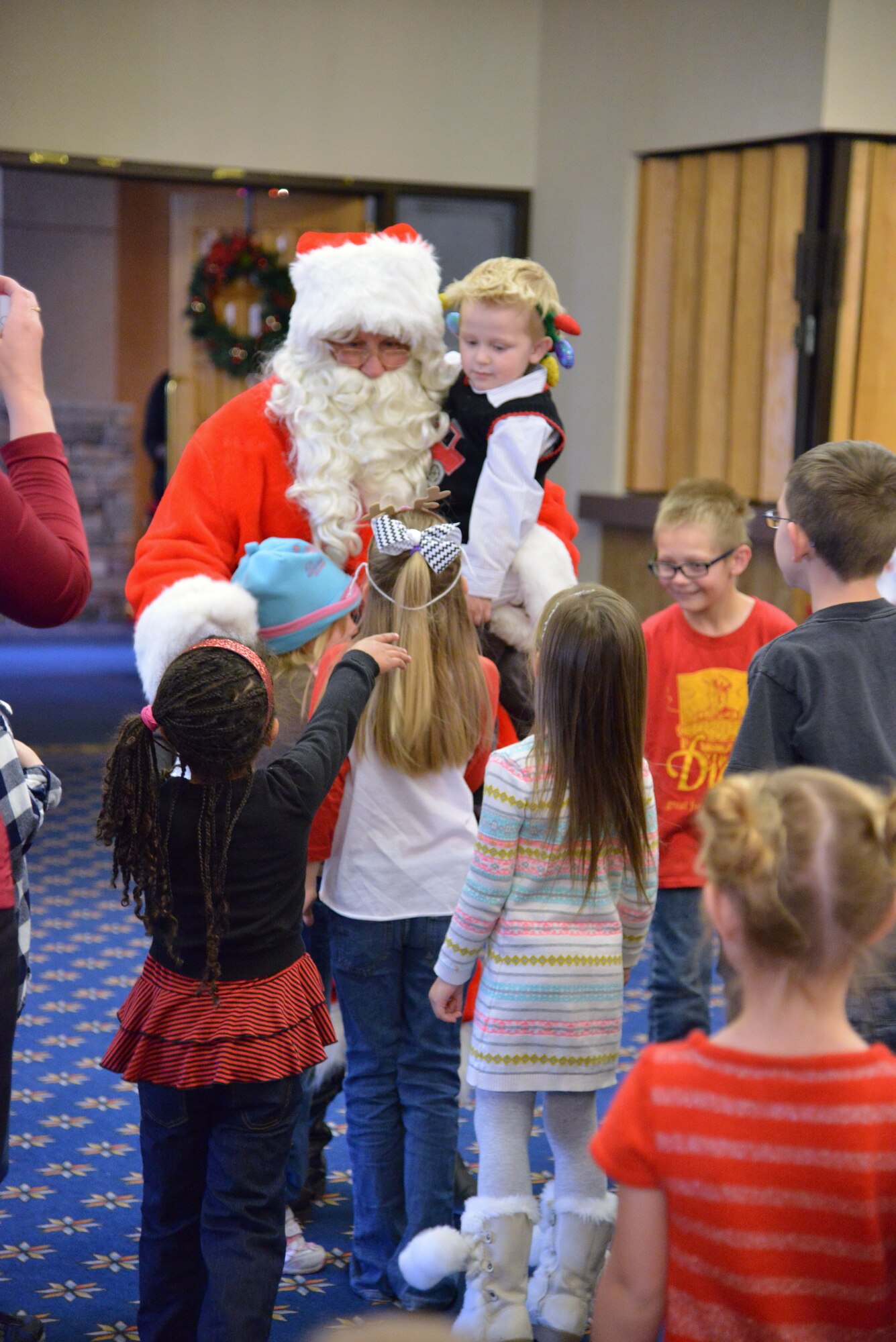Children surround Santa Clause at the Hearts Apart holiday party Dec. 13 at the Mountain View Club. Hearts Apart is an Airman & Family Readiness Center program for family members who are, will be or have been separated because of military commitments such as deployments, temporary duties or remote tours. (Photo by Jamie Burnett)
