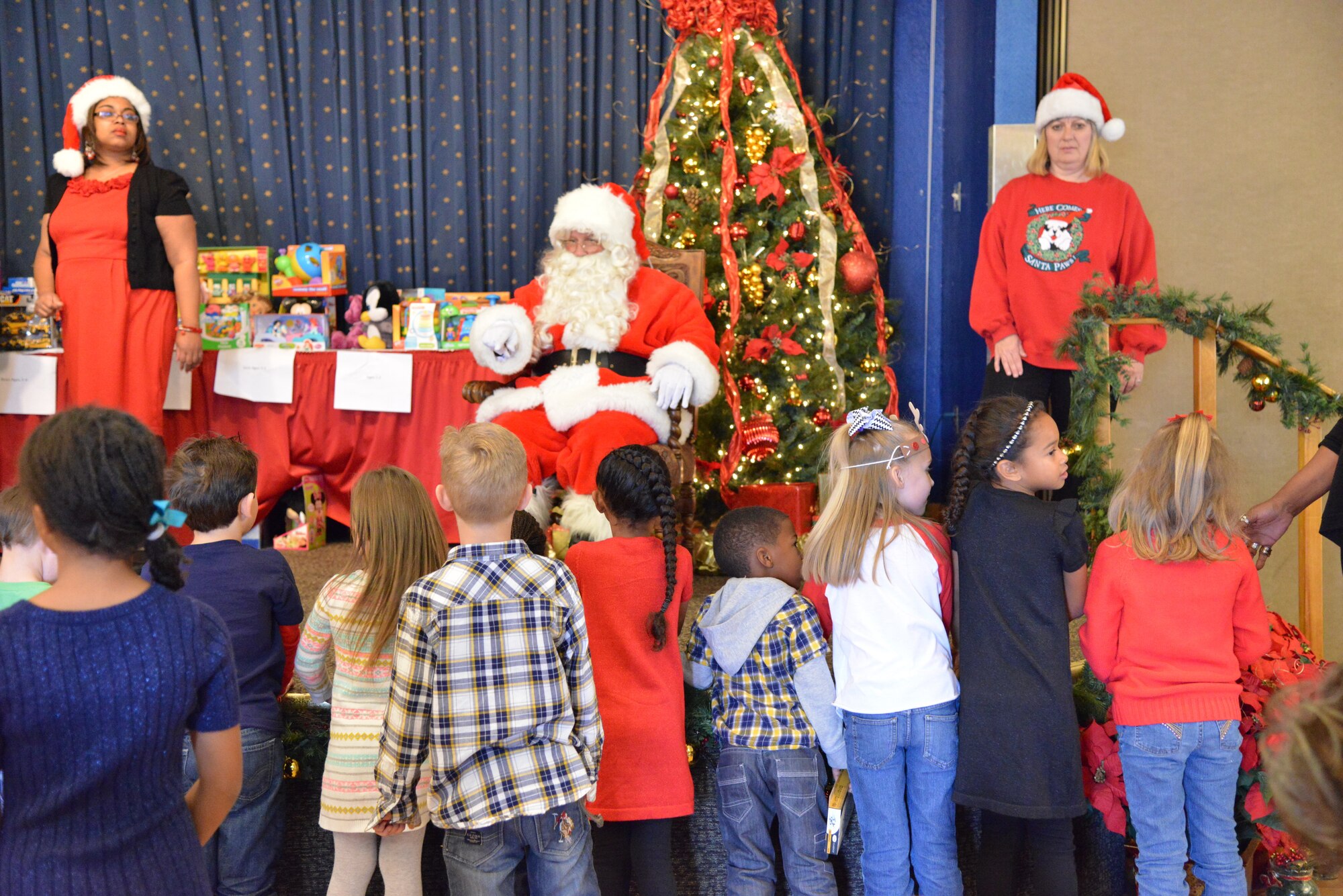 Children line up to see Santa Clause at the Hearts Apart holiday party Dec. 13 at the Mountain View Club. Hearts Apart is an Airman & Family Readiness Center program for family members who are, will be or have been separated because of military commitments such as deployments, temporary duties or remote tours. (Photo by Jamie Burnett)