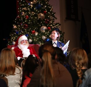 Staff Sgt. Rachel Wilson, U.S. Air Force Band of the West Concert Band vocalist, reads the story of “Rudolph the Red Nosed Reindeer” with Santa Claus to children from the audience during the annual Holiday in Blue Concert Dec. 6 at the Edgewood Theatre of Performing Arts in San Antonio, Texas. The Band of the West is composed of a 60-member squadron comprised of nine different musical configurations. The band executes more than 300 annual musical productions and is responsible for a seven state, 580,000 square mile region. (U.S. Air Force photo by Airman 1st Class Alexandria Slade)