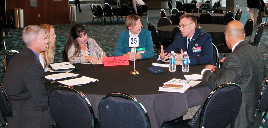 Brig. Gen. Tim Green, Air Force director of civil engineers, and Sally Kite (third from right), chief of the construction flight at the 772nd Enterprise Sourcing Squadron, discuss CE contracting support opportunities with industry representatives during a networking session Dec. 10 at the 2014 Society of American Military Engineers Small Business Conference in Kansas City. (U.S. Air Force photo/Michael Briggs/released)