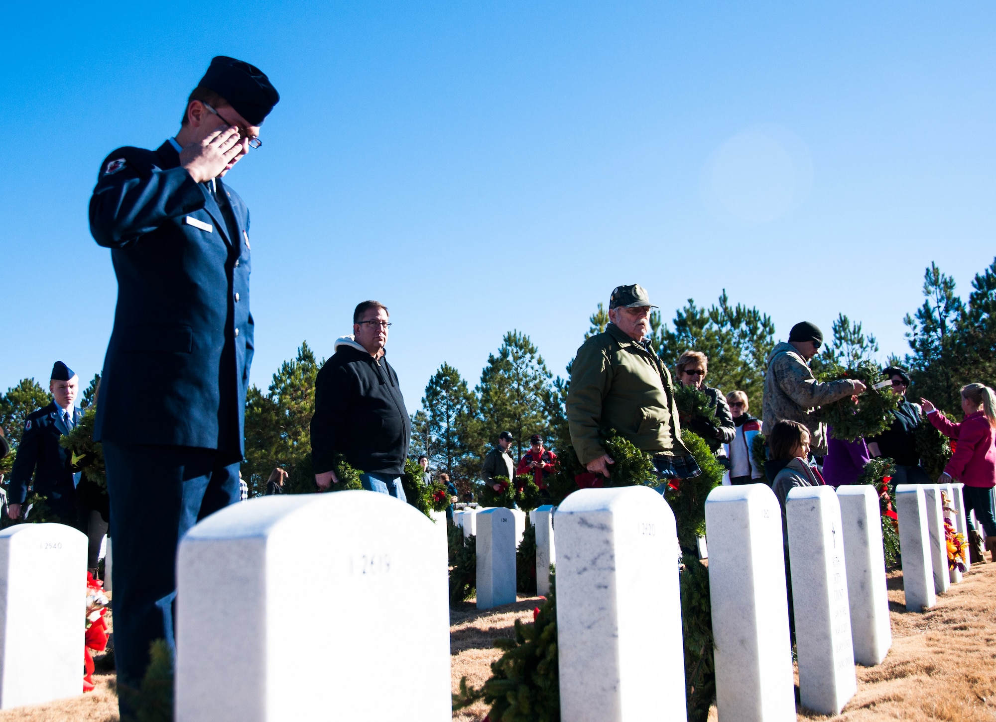 A volunteer salutes a gravestone after laying his wreath at the Wreaths Across America ceremony in Canton, Ga. at Georgia National Cemetery Dec. 13, 2014. Thousands showed up to GNC to honor America’s heroes. (U.S. Air Force photo/Senior Airman Daniel Phelps))