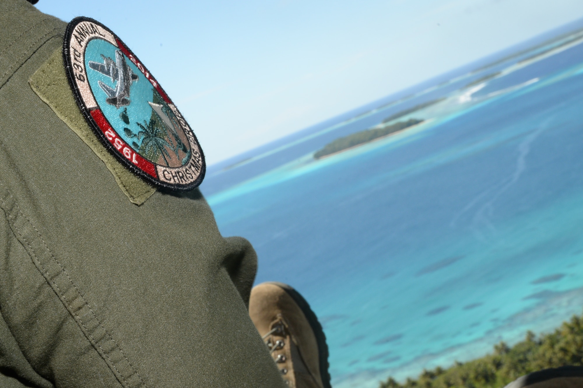 The Operation Christmas Drop patch is displayed on the arm of an aircrew member from Yokota Air Base, Japan, Dec. 11, 2014, over the Pacific Ocean. Operation Christmas Drop, which has occurred since 1952, is the world’s longest humanitarian airlift mission. Each year the operation supplies residents from more than 50 islands with boxes that contain donations to include non-perishable food items, clothing, medical supplies, tools, toys and other various items. (U.S. Air Force photo by Airman 1st Class Amanda Morris/Released)