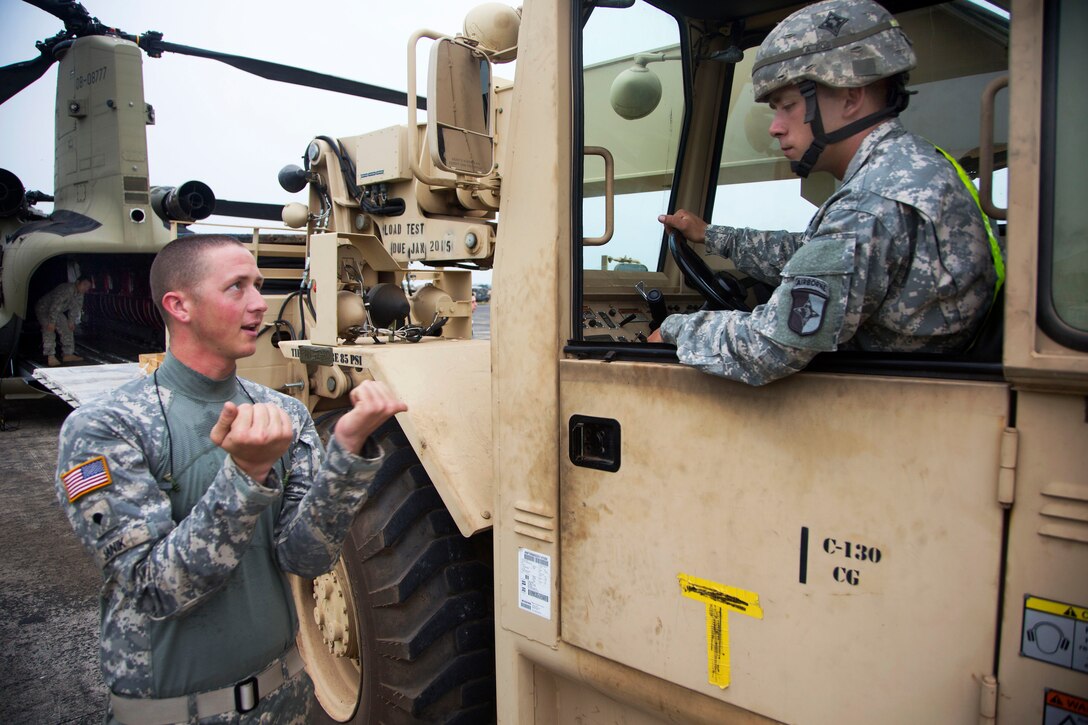 U.S. Army Spc. Tyler Jank, left, gives instructions to U.S. Army Sgt. Kyle Hennick during an airlift of electrical supplies to an Ebola treatment unit being built in support of Operation United Assistance at Roberts International Airport in Monrovia, Liberia, Dec. 12, 2014. Jank is assigned to Task Force Iron Knights and Hennick is assigned to the 372nd Inland Cargo Transportation Company. United Assistance is a Department of Defense operation to provide command and control, logistics, training and engineering support to U.S. Agency for International Development-led efforts to contain the Ebola virus outbreak in West African nations.