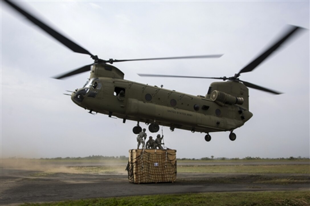 U.S. soldiers attach cargo to a CH-47 Chinook helicopter on Roberts International Airport in Harbel, Liberia, Dec. 12, 2014. The mission was to airlift incinerators to a new ebola treatment unit built in support of Operation United Assistance.