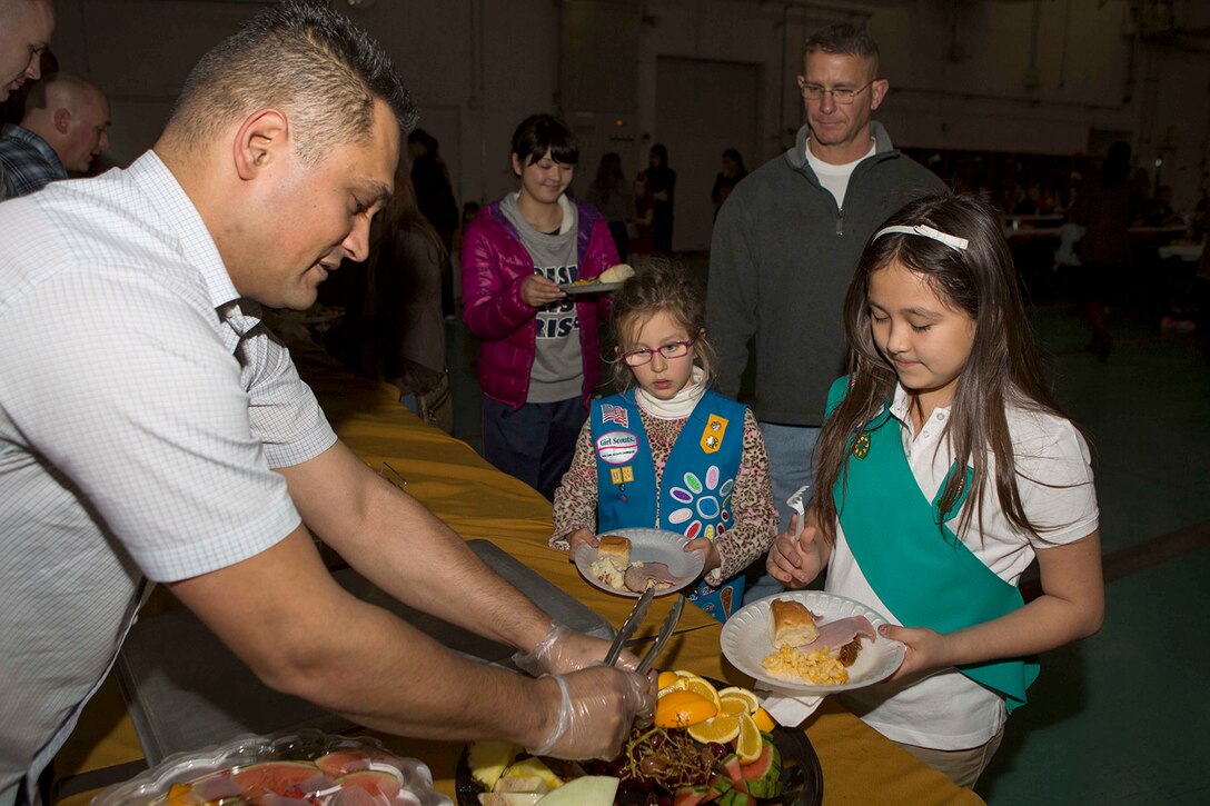Gunnery Sgt. Nathan Lanham, the embarkation chief with Aircraft Rescue Firefighting, passes out fruit to guest of ARFF’s annual holiday party, Dec. 12, 2014, inside the ARFF compound aboard Marine Corps Air Station Iwakuni, Japan. The holiday party was hosted as part of an existing relationship between ARFF and the Tsuta Children’s Home, where members of ARFF invite the children’s home aboard station to spread holiday cheer.