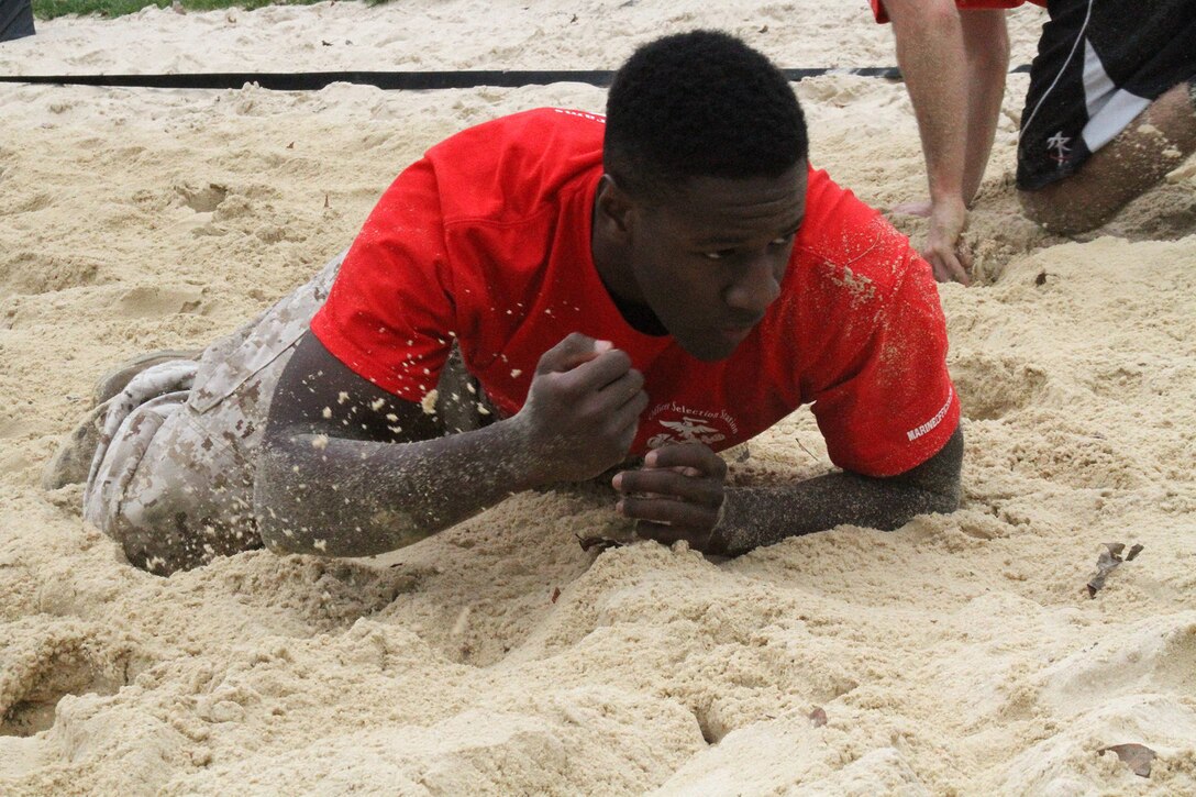 Kalen Banks, a candidate from Marine Corps Officer Selection Team Cincinnati, low crawls through a volleyball sand pit during a pool function at the University of Dayton, Oct. 25, 2014. The pool function consisted of a 45-minute physical training session where the group of approximately 40 Marines and applicants completed a run around campus and land navigation training. (U.S. Marine Corps photo by Sgt. Jennifer Pirante)