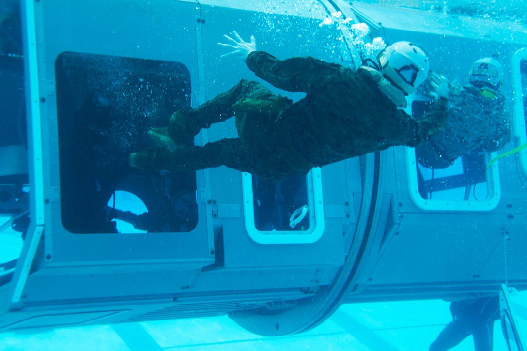 Marines exit a Modular Amphibious Egress Trainer during Underwater Egress Training Dec. 9 at the Hansen Aquatics Center. The Marines are with Combat Logistics Battalion 31, 31st Marine Expeditionary Unit, and they are conducting pre-deployment preparations for the regularly-scheduled Spring Patrol of the Asia-Pacific region. 