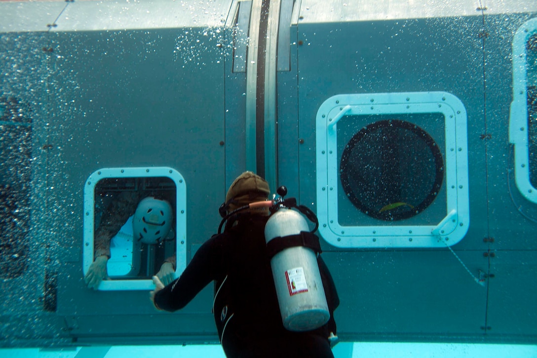 An underwater egress instructor oversees a Marine’s exit from a Modular Amphibious Egress Trainer during Underwater Egress Training Dec. 9 at the Hansen Aquatics Center. The Marines conducting the training are with Combat Logistics Battalion 31, 31st Marine Expeditionary Unit, and they are conducting pre-deployment preparations for the regularly-scheduled Spring Patrol of the Asia-Pacific region. 