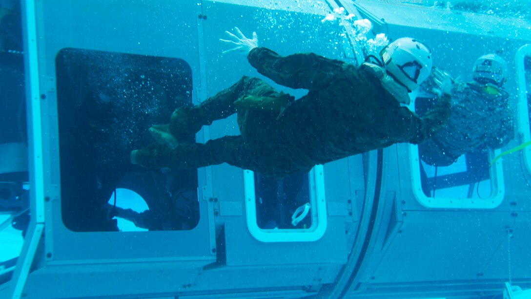 Marines exit a Modular Amphibious Egress Trainer during Underwater Egress Training Dec. 9 at the Hansen Aquatics Center. The Marines are with Combat Logistics Battalion 31, 31st Marine Expeditionary Unit, and they are conducting pre-deployment preparations for the regularly-scheduled Spring Patrol of the Asia-Pacific region.