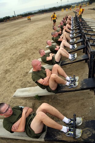 Recruits of Echo Company, 2nd Recruit Training Battalion, perform inclined crunches at Marine Corps Recruit Depot San Diego, Dec. 11. Drill instructors gave the command for recruits to start and stop, and each station lasted approximately three minutes.