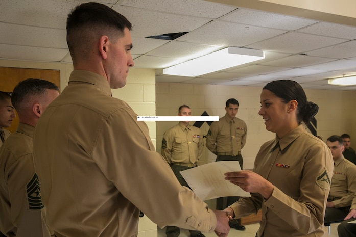 Lance Cpl. Monica Rodriguez (right), a motor vehicle operator with Combat Logistics Battalion 2, Combat Logistics Regiment 2 and a native of Philadelphia, receives her graduation certificate after completing the Corporal Leadership and Professional Ethics Seminar aboard Marine Corps Base Camp Lejeune, N.C., Dec. 12, 2014. The seminar was constructed around group discussions in small classes and focused on focus the Marine Corps’ mission to maintain readiness, create leaders and build ethical citizens both in and out of uniform.