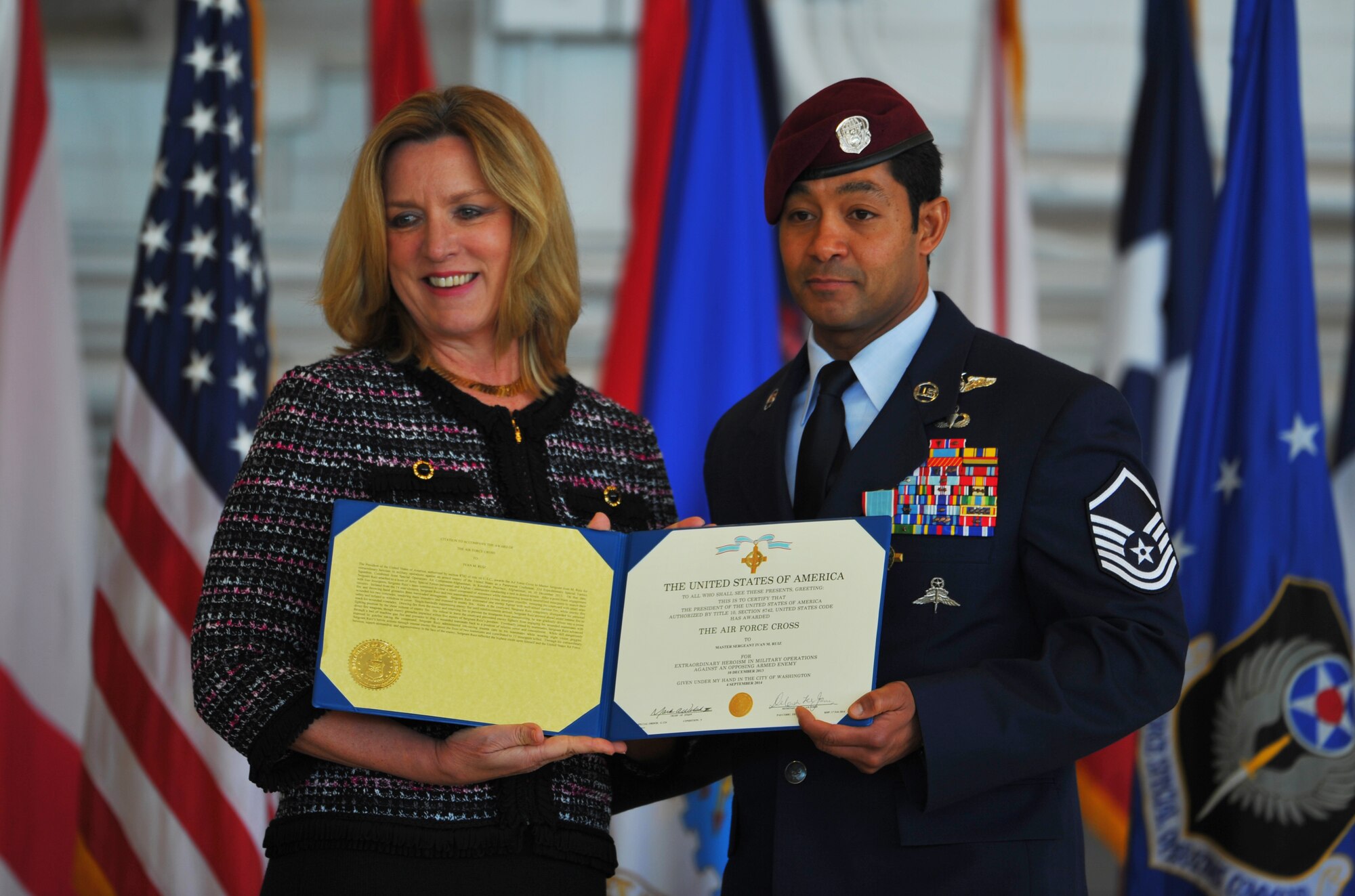 Master Sgt. Ivan Ruiz, a pararescueman from the 56th Rescue Squadron, Royal Air Force Lakenheath, England, displays his Air Force Cross citation with Secretary of the Air Force Deborah Lee James at the Freedom Hangar on Hurlburt Field, Fla., Dec 17, 2014. Ruiz earned the Air Force Cross while deployed with the 22nd Expeditionary Special Tactics Squadron, and assigned to the 23rd STS at Hurlburt Field, Fla. The last six Air Force Crosses have all been awarded to AFSOC Special Tactics Airmen.  (U.S. Air Force photo/Airman 1st Class Jeff Parkinson)