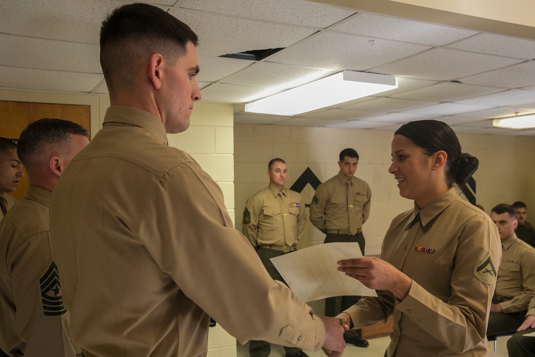 Lance Cpl. Monica Rodriguez (right), a motor vehicle operator with Combat Logistics Battalion 2, Combat Logistics Regiment 2 and a native of Philadelphia, receives her graduation certificate after completing the Lance Corporal Leadership and Professional Ethics Seminar aboard Marine Corps Base Camp Lejeune, N.C., Dec. 12, 2014. The seminar was constructed around group discussions in small classes and focused on focus the Marine Corps’ mission to maintain readiness, create leaders and build ethical citizens both in and out of uniform.