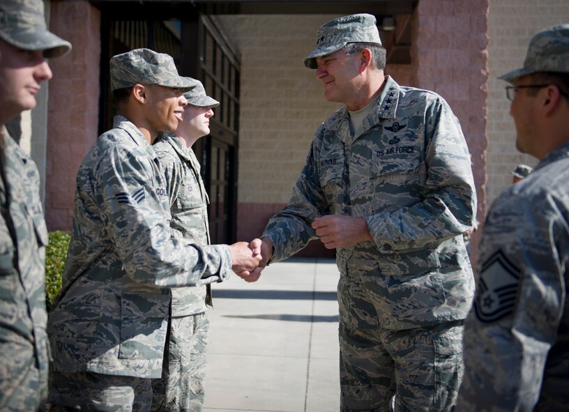 Lt. Gen. Bradley Heithold, Air Force Special Operations Command commander, coins Senior Airman Marquise Coleman, 1st Special Operations Aerospace Medicine Squadron medical system journeyman, during his tour of the 1st Special Operations Medical Group at Hurlburt Field, Fla., Dec. 11, 2014. Heithold discussed various subjects such as, the AFSOC mission and the importance of family.  (U.S. Air Force photo/Senior Airman Krystal M. Garrett)