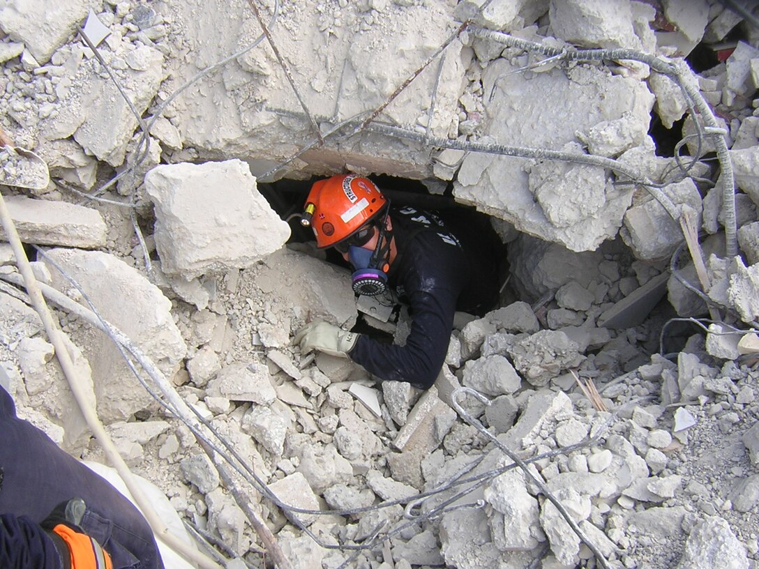 Scott Acone, a U.S. Army Corps of Engineers rescue engineer, emerges from wreckage of the Hotel Montana in Port-au-Prince, Haiti, during recovery efforts after the devastating earthquake of January 2010.