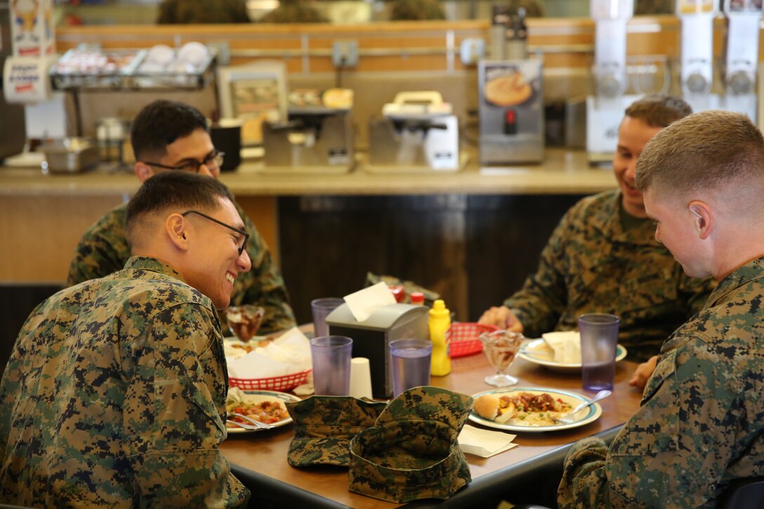 Marines enjoy hot dogs during a visit from chefs George Kapetsonis and Romulo Partido to the Littleton mess hall, Dec. 2, 2014. These chefs came to the Combat Center as part of Sodexo’s food initiative. (Official Marine Corps photo by Lance Cpl. Medina Ayala-Lo/Released)