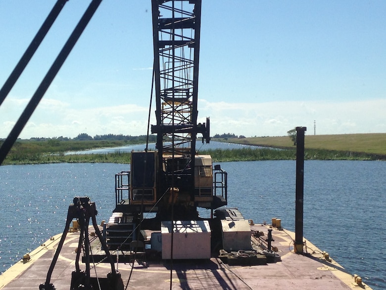 The tug boat Leitner pushed a barge mounted crane into position so a crew could break up and remove a half-acre tussock or floating island, restoring navigation along the Rim Canal Route 2 of the Okeechobee Waterway and the south side of Lake Okeechobee.