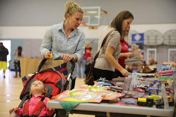 Nicole Hart, military spouse, browses for toys during Operation Homefront’s holiday distribution at the Community Center, Dec. 3, 2014. OHF receives corporate and individual donations that make their giveaways possible. (Official Marine Corps photo by Lance Cpl. Medina Ayala-Lo/Released)