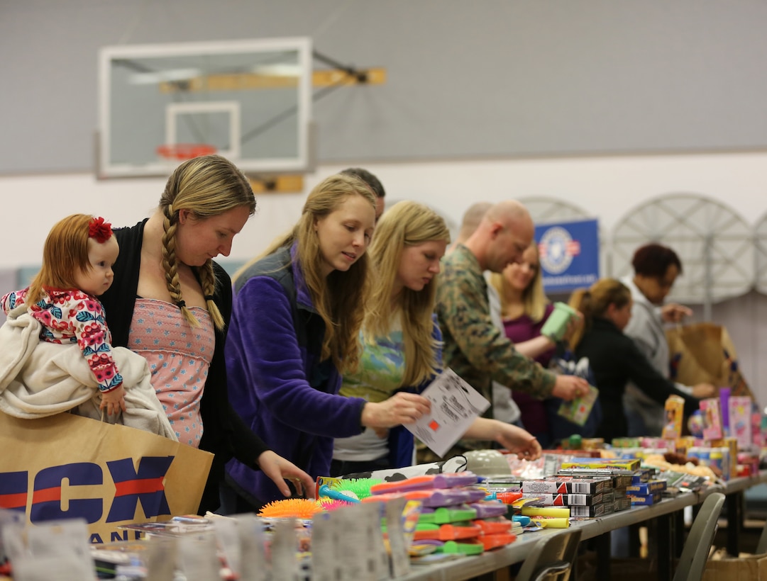 Parents pick out toys during Operation Homefront’s holiday distribution at the Community Center, Dec. 3, 2014. Programs like OHF are designed to provide parents and family members with relief during hectic times of the year. (Official Marine Corps photo by Lance Cpl. Medina Ayala-Lo/Released)