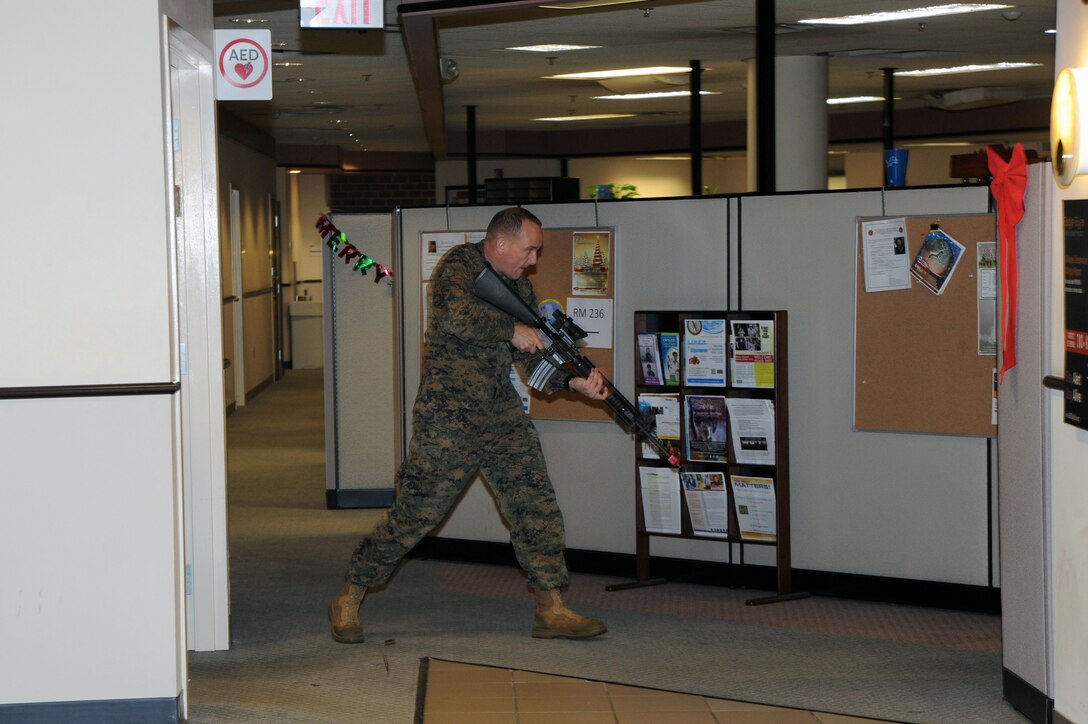 Lt. Col. Shane Gouker, operations officer for Futures Directorate, Combat Development and Integration Department, plays the role of a renegade shooter at The Raymond G. Davis Center aboard Marine Corps Base Quantico during an active-shooter drill with role players Tuesday.