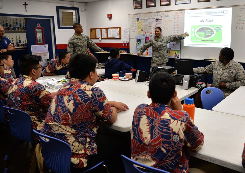 Senior Master Sgt. Dejnekki Peyton, 15th Medical Group Education and Training flight chief, teaches St. Louis School Army Junior Reserve Officer Training Corps cadets portion control techniques during a lesson on nutrition Dec. 17, 2014, in Honolulu, Hawaii. Peyton and other 15th MDG education and training flight members visit the JROTC cadets at least once a month to provide them basic medical and health training. (U. S. Air Force photo by Staff Sgt. Alexander Martinez/Released)
