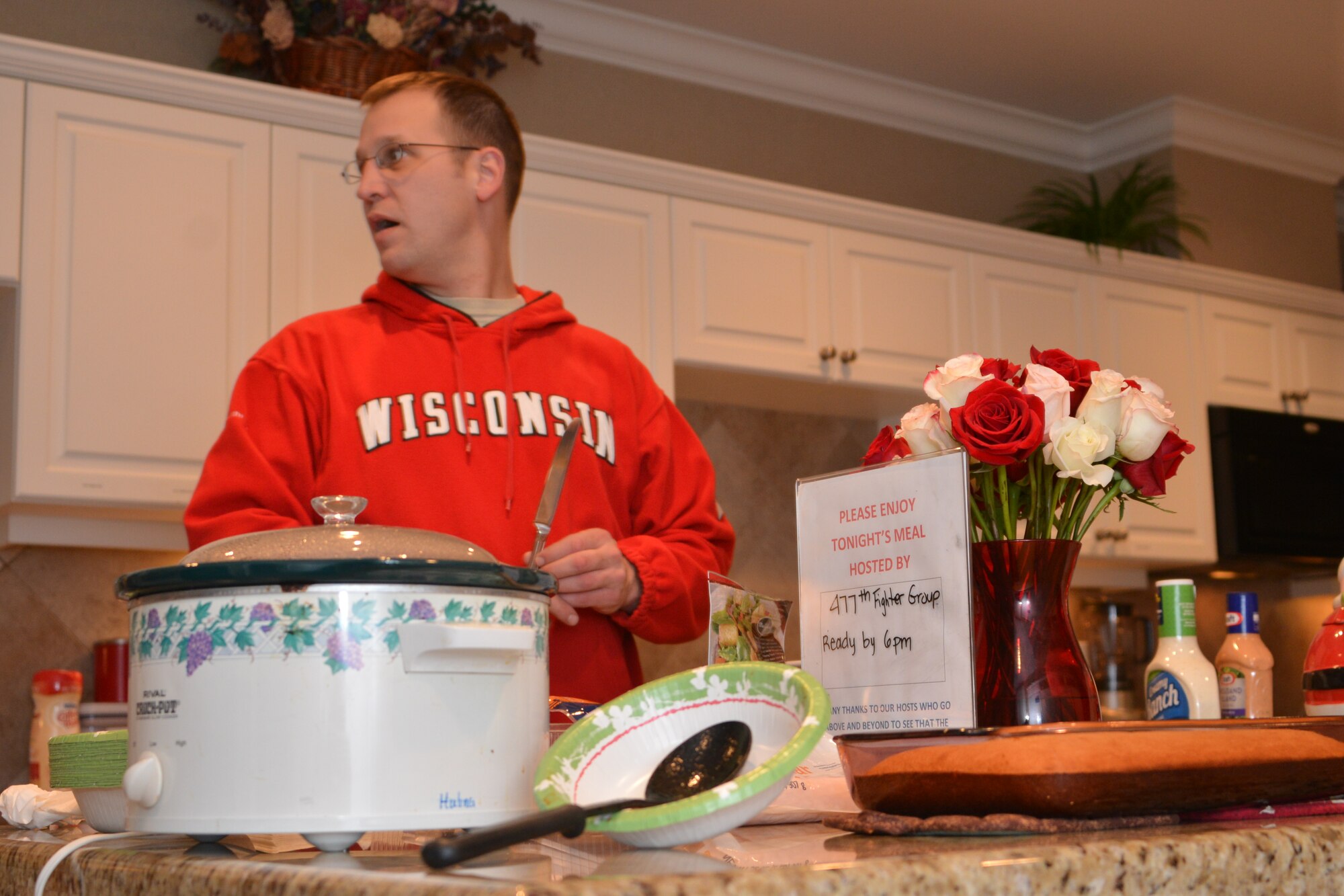 Master Sgt. Travis Schlapbach, 477th MXS, helps prepare dinner for Fisher House residents here recently. The 477th Fighter Group provides support for Fisher House on the first Wednesday of every month by bringing and fixing dinner. (U.S. Air Force Photo/Tech. Sgt. Dana Rosso)