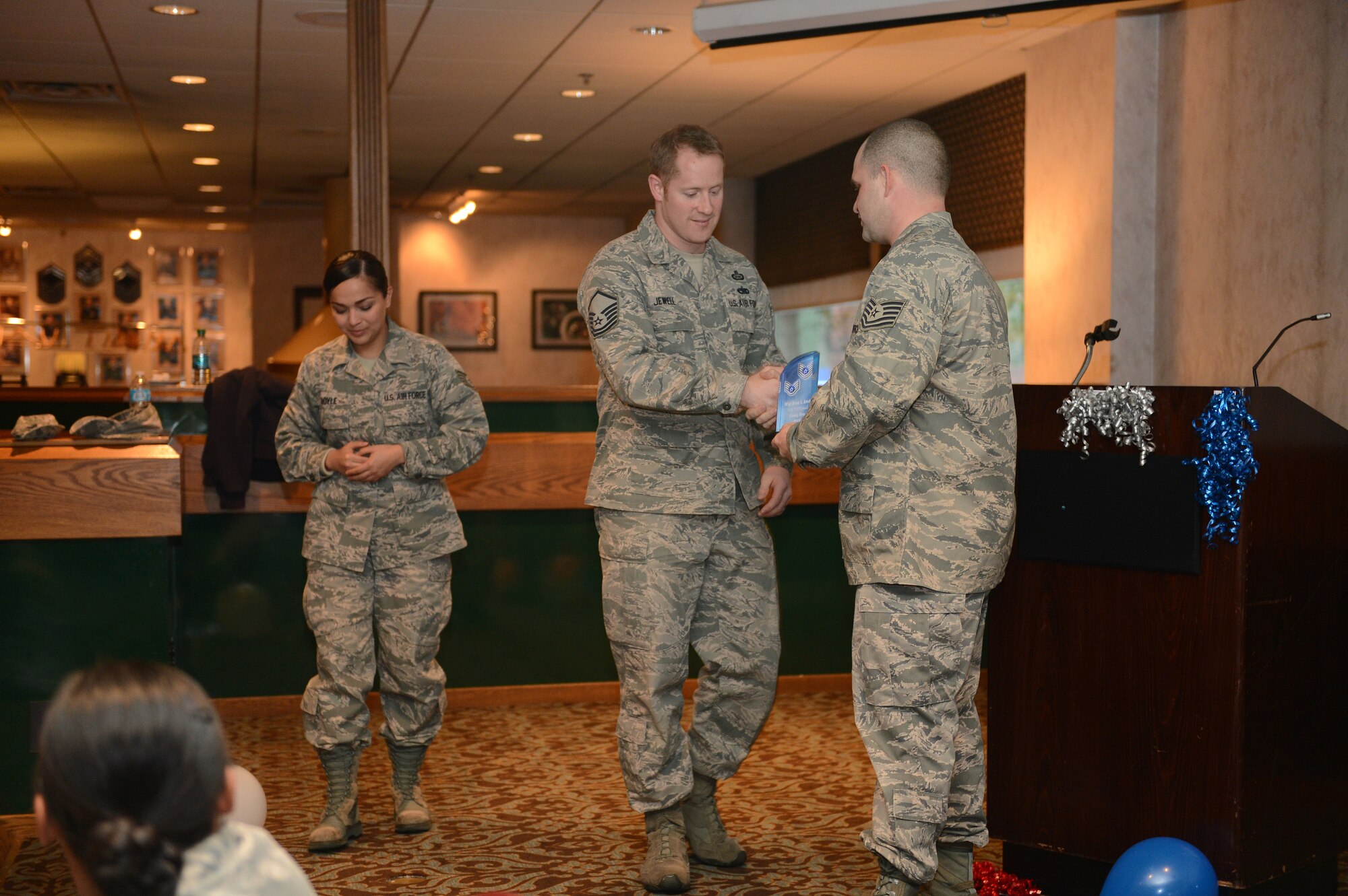 Tech. Sgt. James Lee (right), Julius A. Kolb Airman Leadership School instructor, presents Master Sgt. Brian Jewell, 1st Air Support Operations Group superintendent of intelligence with a 5/6 Council Unsung Hero Award on behalf of the 5/6 Council Dec. 12, 2014, at the McChord Club at Joint Base Lewis-McChord, Wash. Jewell worked as the liason between the 5/6 Council and the Top Three on McChord Field, discussing any concerns between the two. (U.S. Air Force photo/Airman 1st Class Keoni Chavarria)