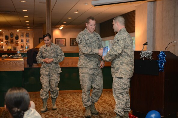 Tech. Sgt. James Lee (right), Julius A. Kolb Airman Leadership School instructor, presents Master Sgt. Brian Jewell, 1st Air Support Operations Group superintendent of intelligence with a 5/6 Council Unsung Hero Award on behalf of the 5/6 Council Dec. 12, 2014, at the McChord Club at Joint Base Lewis-McChord, Wash. Jewell worked as the liason between the 5/6 Council and the Top Three on McChord Field, discussing any concerns between the two. (U.S. Air Force photo/Airman 1st Class Keoni Chavarria)