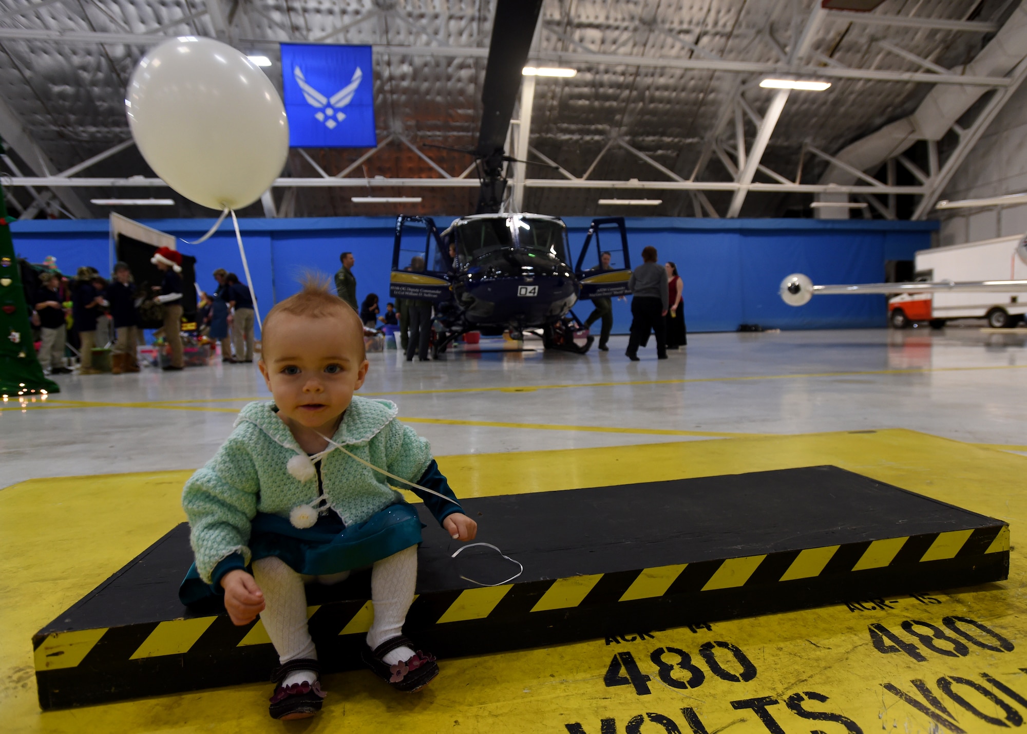 Karli, daughter of U.S. Army Lt. Col. Tom Manoin, plays around during the Parents and Children Fighting Cancer Holiday Party on Joint Base Andrews, Md., Dec. 13, 2014.  More than 250 volunteers collaborated together for the 27th annual event. (U.S. Air Force photo/ Senior Airman Nesha Humes)