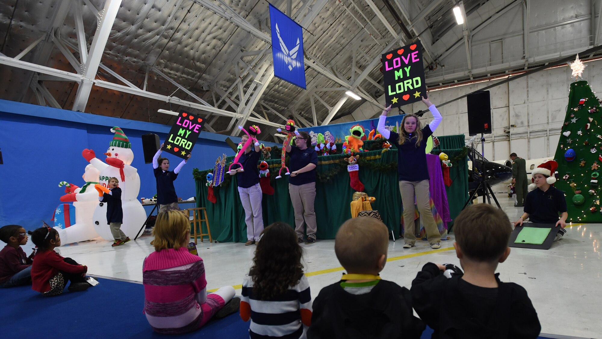 Attendees of the Parents and Children Fighting Cancer Holiday Party watch the Berryville Baptist Rascals’ puppet show on Joint Base Andrews, Md., Dec. 13, 2014.  The Rascals’ mission is to present programs with contemporary Christian, Sunday school, country and rock-and-roll music selections that share positive messages focusing on Christian values and kindness. (U.S. Air Force photo/ Senior Airman Nesha Humes)