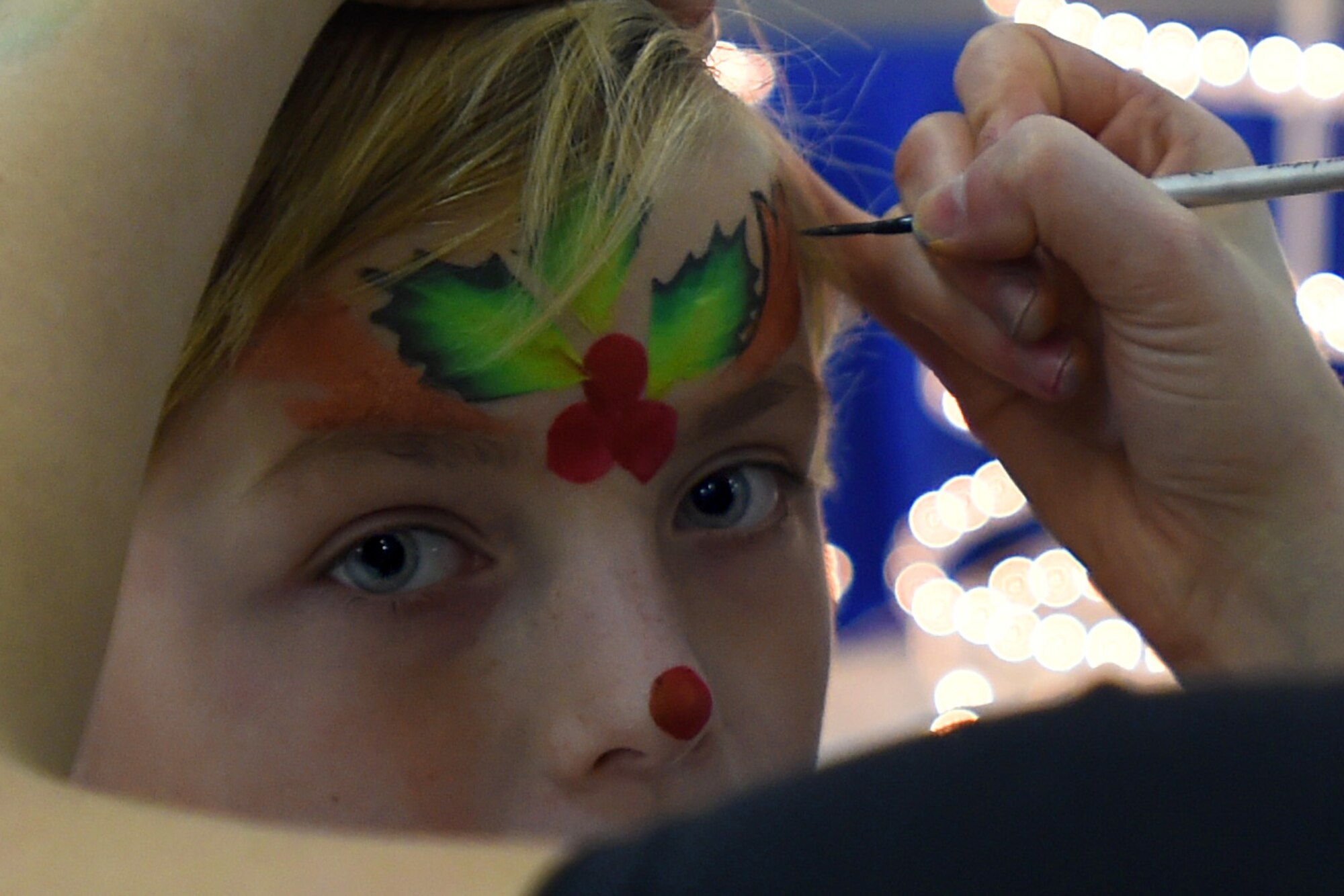 Ali, daughter of U.S Navy Cryptologic Technician (Maintenance) 1st Class Leslie Trotta, has her face painted during the Parents and Children Fighting Cancer Holiday Party on Joint Base Andrews, Md., Dec. 13, 2014.  PCFC is a non-profit organization and support group for families who are receiving treatment, or have previously received treatment, at Walter Reed National Military Medical Center. (U.S. Air Force photo/ Senior Airman Nesha Humes)