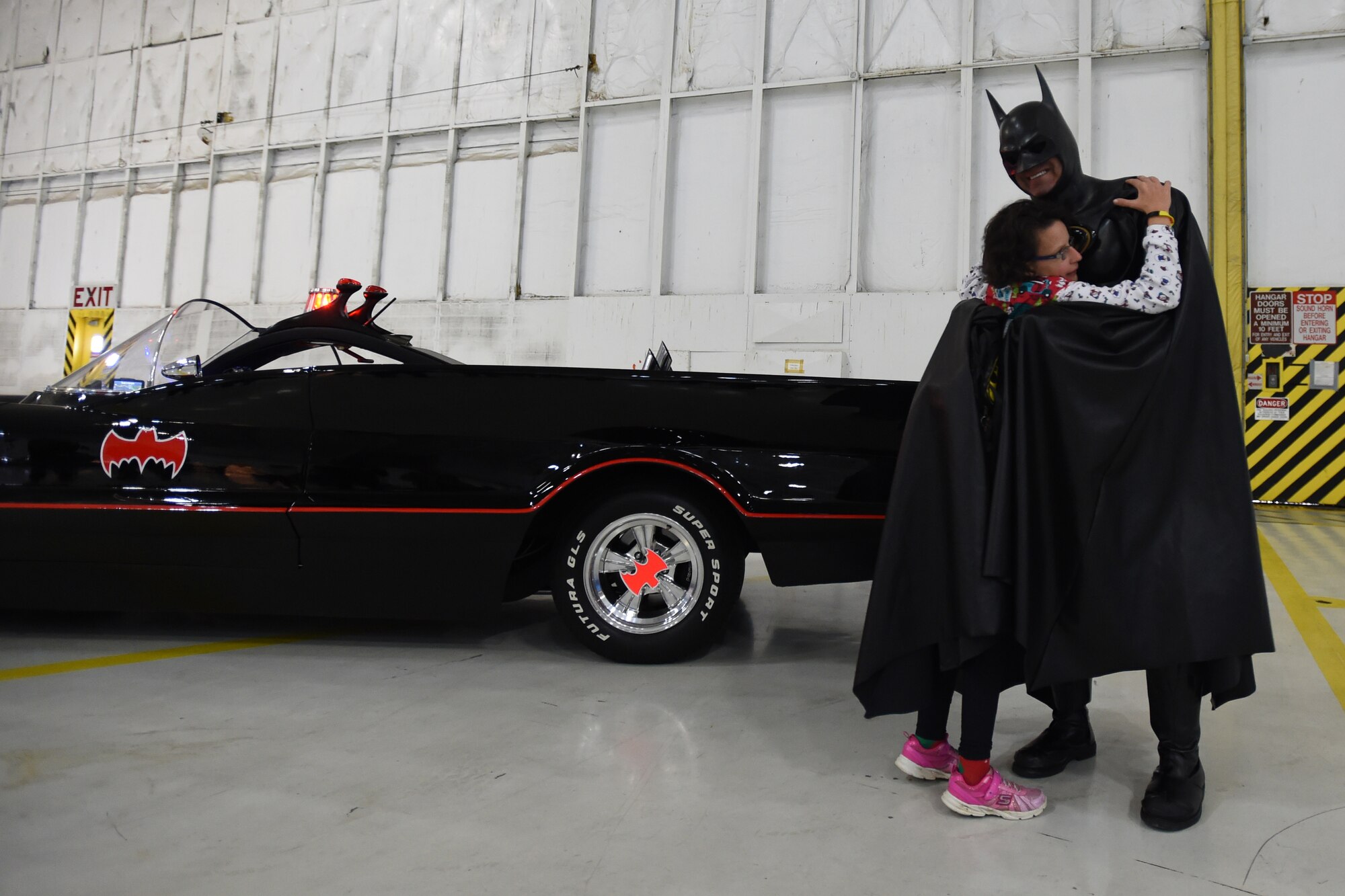 Jennifer Campbell, daughter of retired Air Force Tech Sgt. Tom Campbell, hugs Batman during the Parents and Children Fighting Cancer Holiday Party on Joint Base Andrews, Md., Dec. 13, 2014. The 27th annual event was held for Walter Reed National Military Medical Center pediatric oncology patients and their families to celebrate the holiday season. (U.S. Air Force photo/ Senior Airman Nesha Humes)