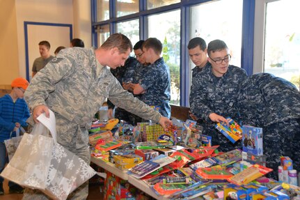 Technical Sgt. Jack Gilson, 628th Civil Engineer Squadron, looks for the perfect toys during the Operation Homefront, Balfour Beatty toy give-away, Dec. 11, 2014, at the Community Center on Joint Base Charleston, S.C. Balfour Beatty teamed up with Operation Homefront to provide hundreds of toys for Sailors, Airmen and their families. A national nonprofit, Operation Homefront leads more than 2,500 volunteers with nationwide presence who provide emergency and other financial assistance to the families of service members and wounded warriors. Operation Homefront has provided assistance to thousands of military families since its inception in 2002. (U.S. Air Force photo/Eric Sesit)
