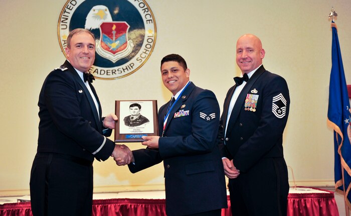 Senior Airman Daniel Deel, 437th Operation Support Squadron, accepts the John L. Levitow Award during the Airman Leadership School graduation at the air base club on Joint Base Charleston, S.C., Dec. 11, 2014. The Levitow award is the highest award given during ALS, and is given for overall outstanding achievement in academics, evaluations and judgment. (U.S. Air Force photo/Staff Sgt. Renae Pittman)