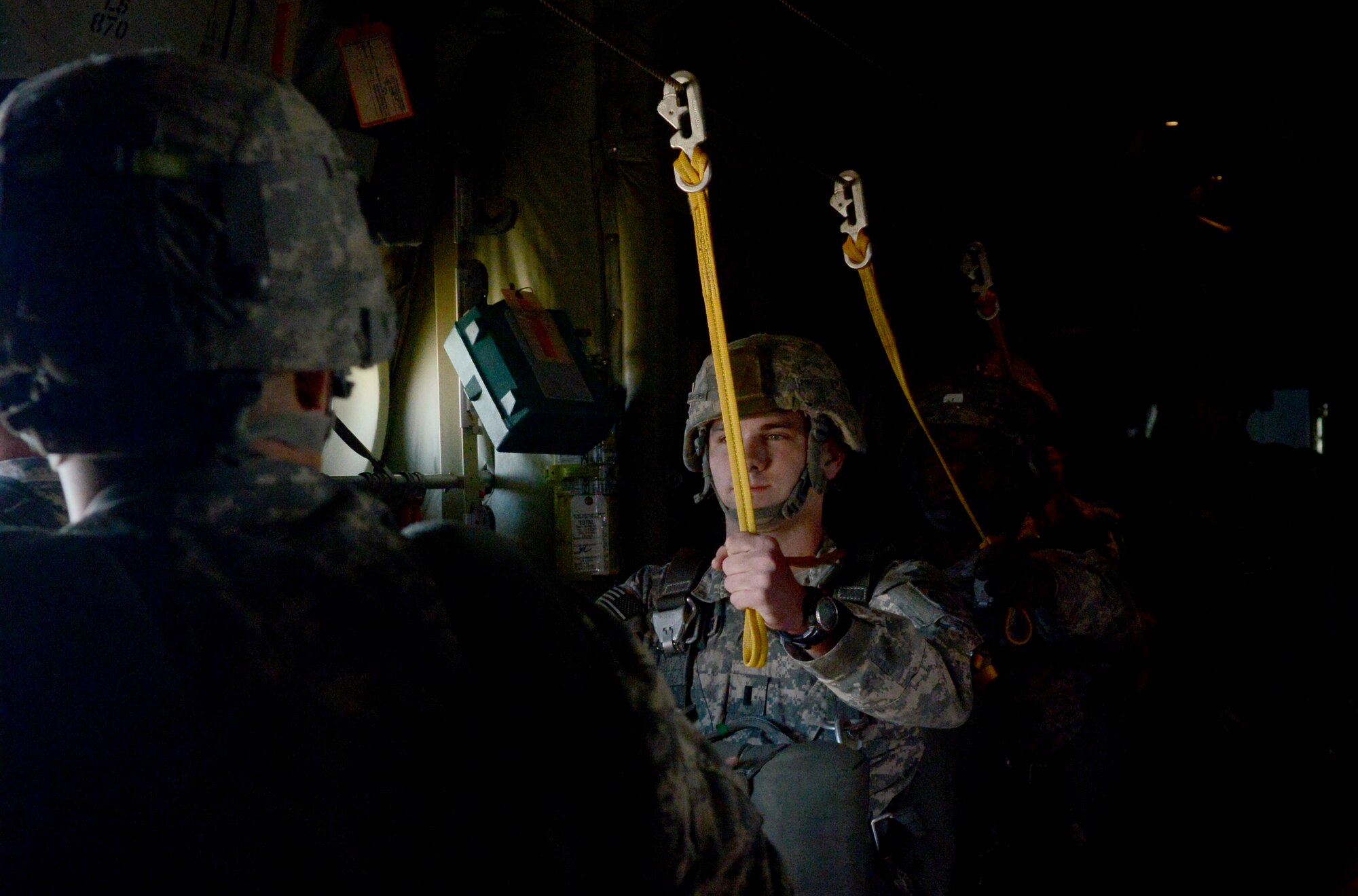 U.S. Army 2nd Lt. Paul Baumgartner, 82nd Airborne Division, listens to a jumpmaster  before parachuting from a C-130J Super Hercules during a joint forcible entry exercise Dec. 6, 2014, at Nellis Air Force Base, Nev. During the exercise, various units came together to simulate a forcible entry similar to what they may face during real-world scenarios. (U.S. Air Force photo by Airman 1st Class Autumn Velez/Released)